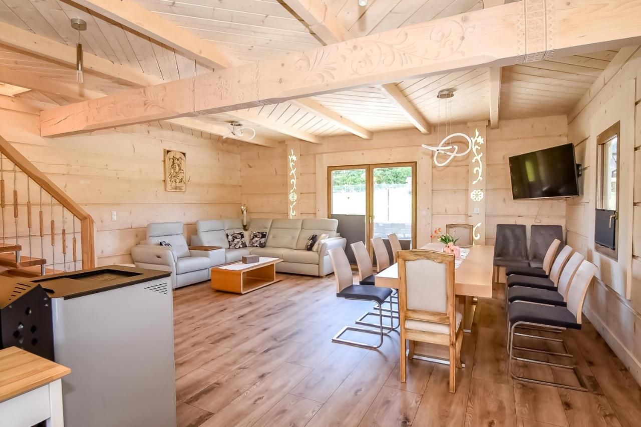 Salon z jasnego drewna z narożną sofą i jadalnią