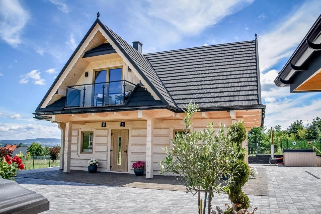 Domek z bali od frontu, z balkonem pod szczytem dachu