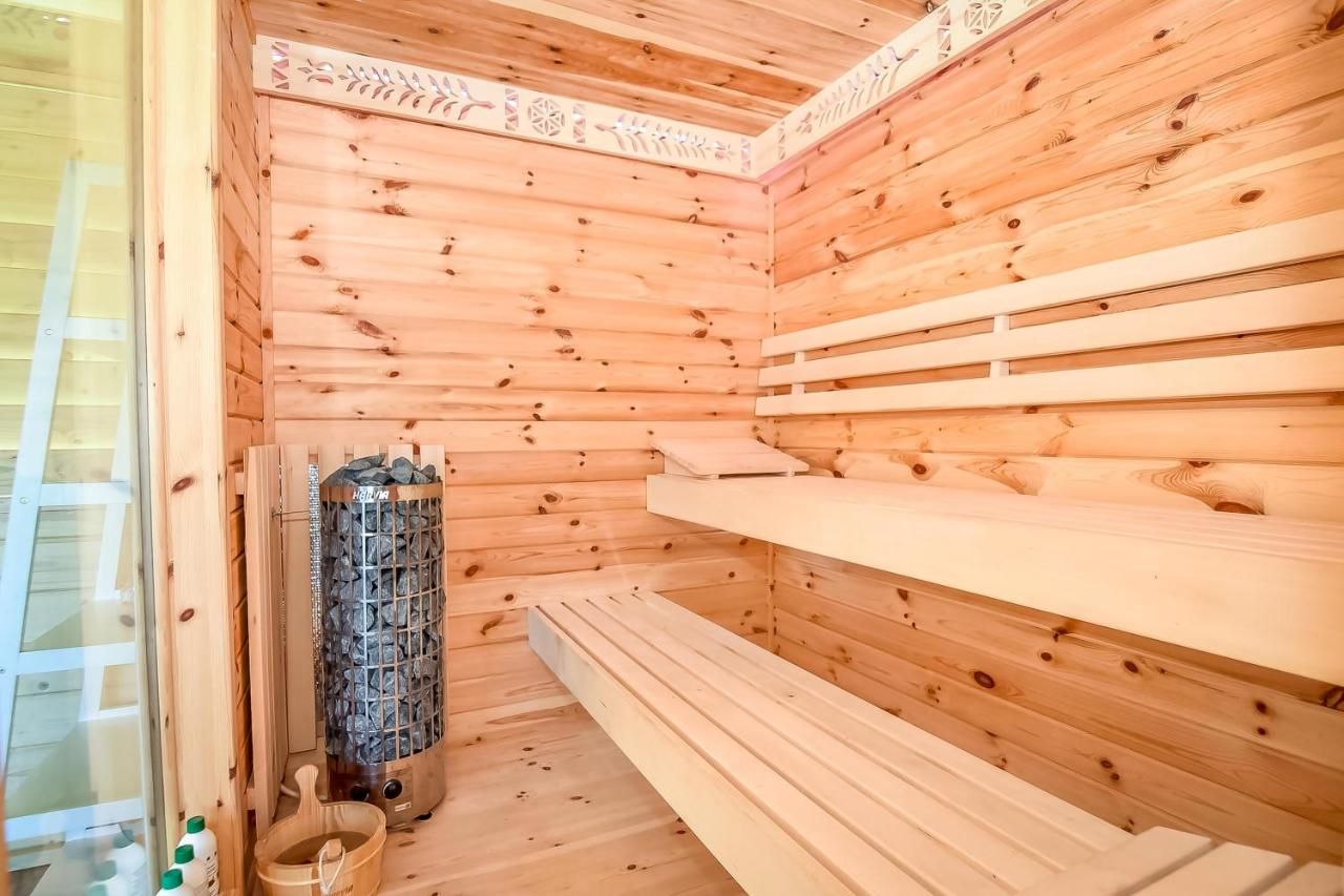 Drewniana sauna z piecem na kamienie i ławami